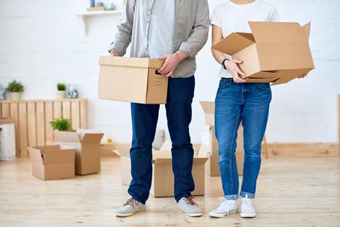 An anonymous couple carry moving boxes