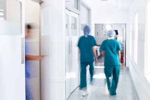 Surgeons wearing scrubs walk to theatre in hospital