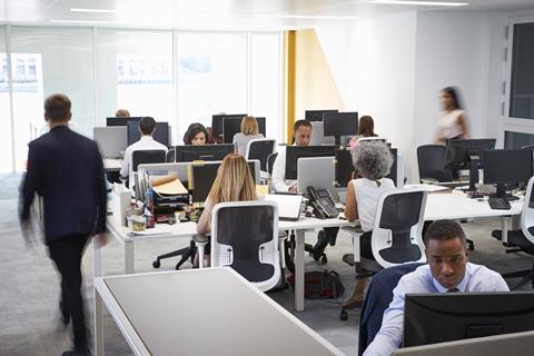 A group of colleagues work at their desks in the office