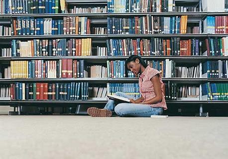 Student in library reading a book