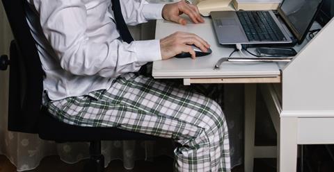 Man on laptop at desk in pyjamas
