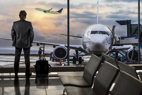 Business man stood at airport gate waiting to board plane