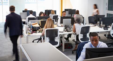 A group of colleagues work at their desks in the office