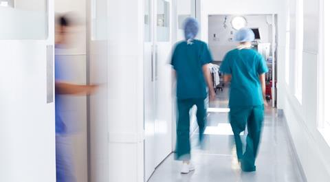 Surgeons wearing scrubs walk to theatre in hospital