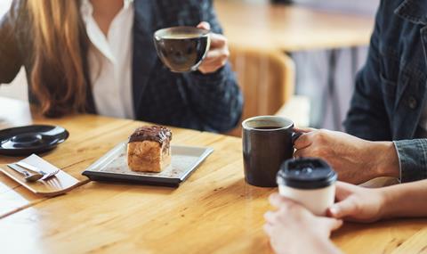 Colleagues chat with coffee and cake