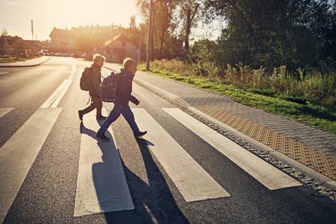 Two young boys crossing the road on their way to school
