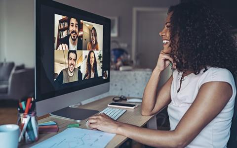 A young woman chats with colleagues in a virtual meeting