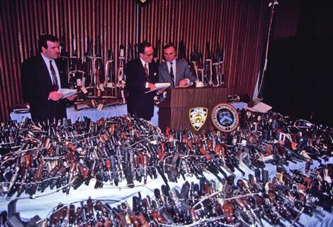 Rudy Giuliani and Bill Bratton pose with guns seized or turned in as part of an initiative to get firearms off the streets of New York