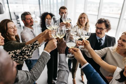 Colleagues clink wine glasses together