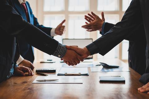 Two parties shake hands in a business meeting