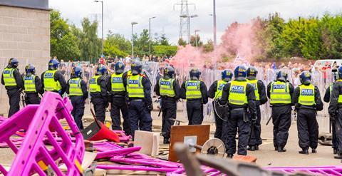 Police attempt to protect a sieged hotel as hundreds of police and rioters clash outside a Holiday Inn Express, Rotherham