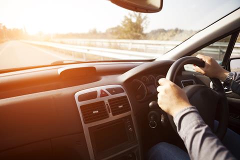 Close up shot of car dashboard with driver behind the wheel