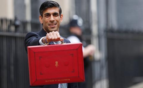 Chancellor of the Exchequer Rishi Sunak stands outside No 11 Downing Street and holds up the traditional red box that contains the budget speech