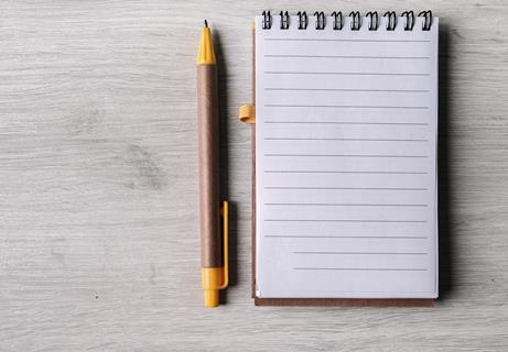 A pen and notepad next to each other on a table