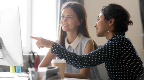 Two young women working together in an office