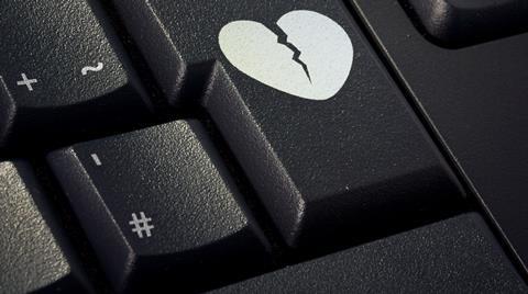 A broken heart graphic on the enter key of a computer keyboard
