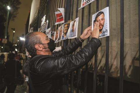 A man hangs pictures of five journalists who were murdered in Mexico in 2022