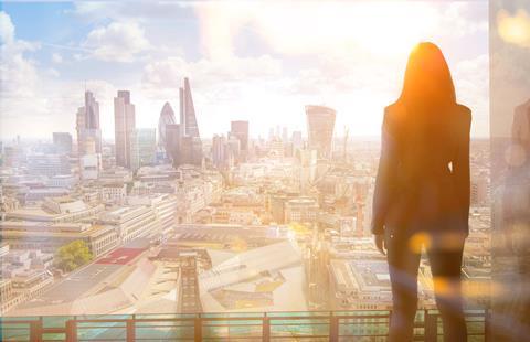 A City worker looks out over the City of London skyline