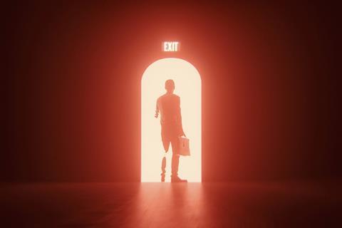 An anonymous man walks through an exit door