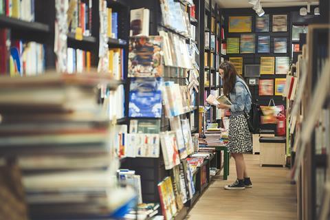 A young woman browses the shelves in a bookshop