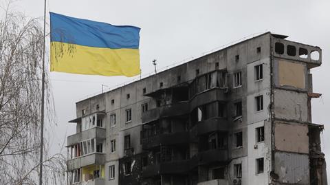 A Ukrainian flag flies in front of an apartment building that was damaged as a result of shelling by Russian troops in Borodianka