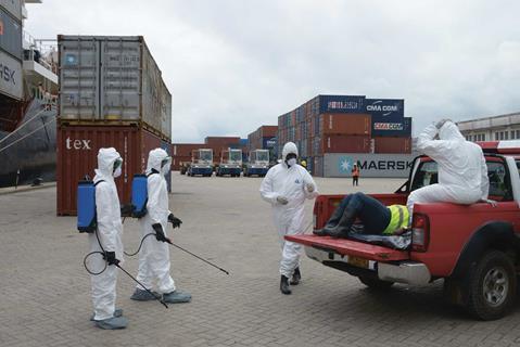 Health workers in protective suits conduct an Ebola prevention drill in Monrovia, Liberia