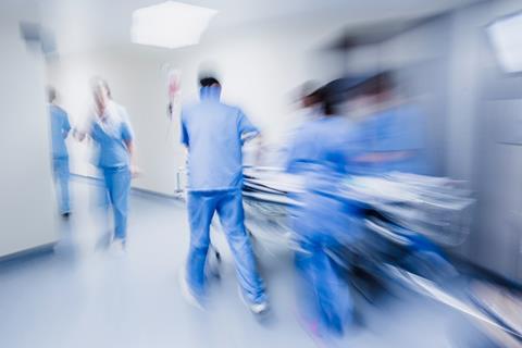 Blurred figures of hospital staff in scrubs rushing patient to surgery