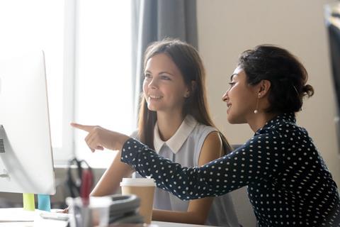 Two young women working together in an office