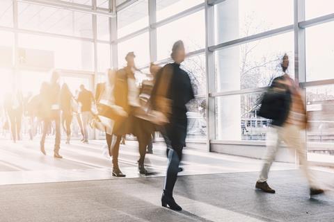 Blurred office workers walking into building