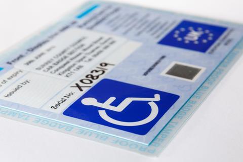 Blue badge card with wheelchair symbol for disabled parking concessions scheme