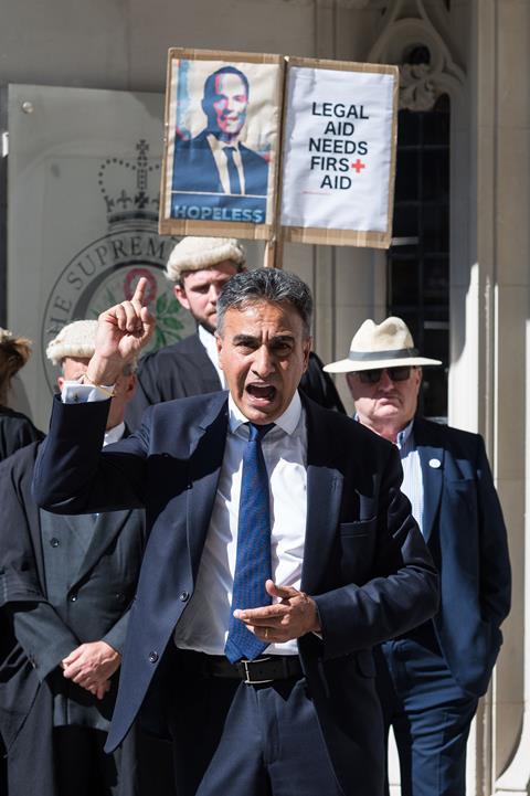 Jo Sidhu QC, chair of the Criminal Bar Association, speaks as criminal barristers, wearing robes and wigs, gather outside the Supreme Court