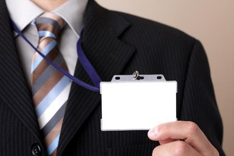 Man wearing buisness suit shows ID card