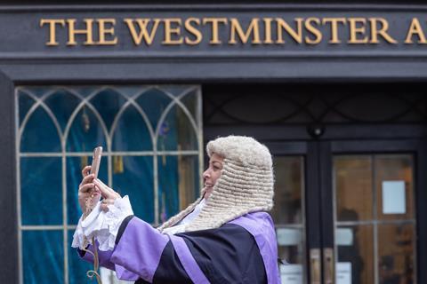 A judge stops to take a photo outside Westminster Abbey before the opening of the legal year