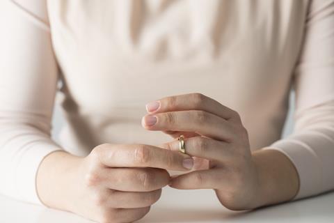 An anonymous woman removes her wedding ring