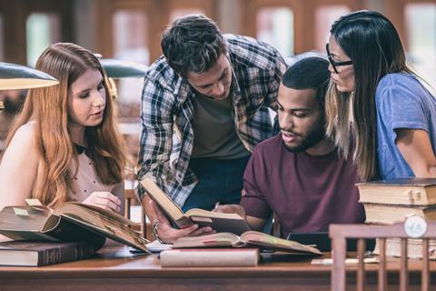 Four university students work together in a library