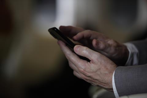 A close up of an anonymous man holding a phone in his hands