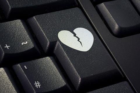 A broken heart graphic on the enter key of a computer keyboard