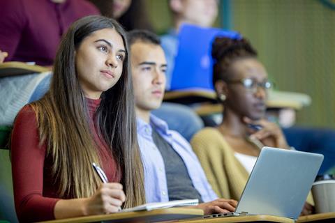 Students writing notes in a university lecture