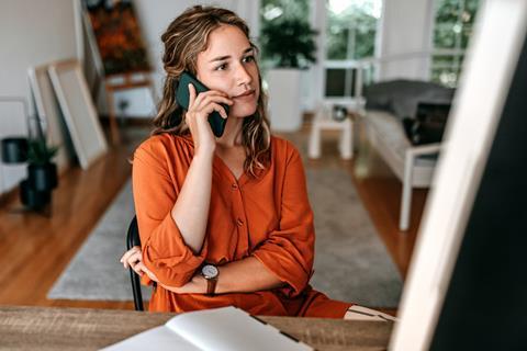 A woman is kept on hold on a phone call