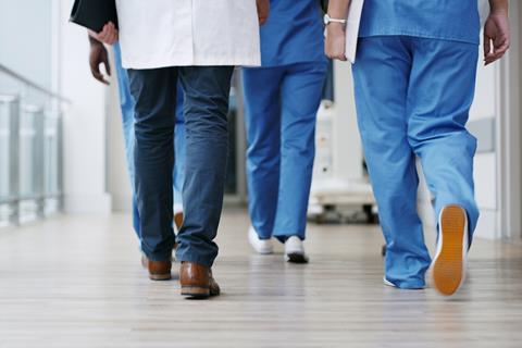 Hospital staff walk down the corridor