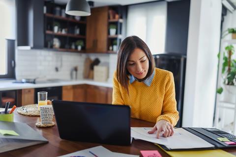 A young woman works from her kitchen table