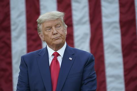 President Donald Trump stands infront of the American flag