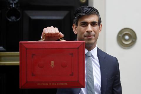 Chancellor Rishi Sunak stands with his red briefcase in front of 11 Downing Street