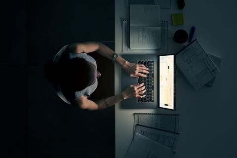 Woman sat at laptop working late at night