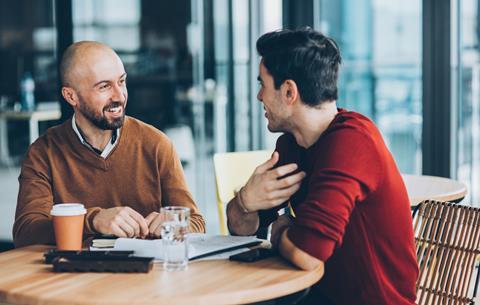 Two male colleagues chat together