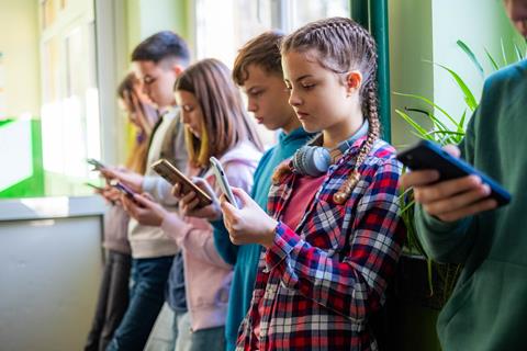 A group of children scroll on their phones