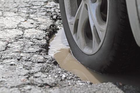 A car drives through a pothole